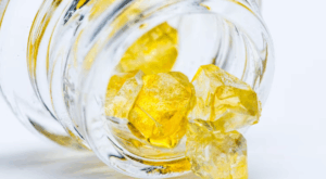 Close-up of THCA diamond cannabis concentrate crystals in a glass jar, available at Fresh Green Dispensaries.