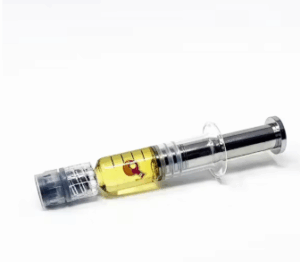 Cannabis distillate syringe filled with golden oil concentrate, used for precise dosing or vaporization